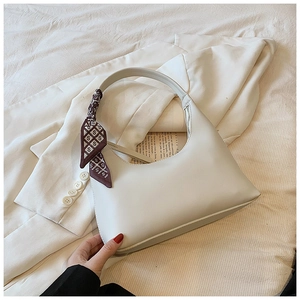 Detail view of cream PU leather shoulder bag with decorative geometric S-pattern silk scarf