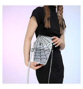 Detail view of silver spider web bag with reflective material and small spider charm
