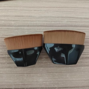 Close-up of two professional 55 flat top foundation brushes with black faceted handles