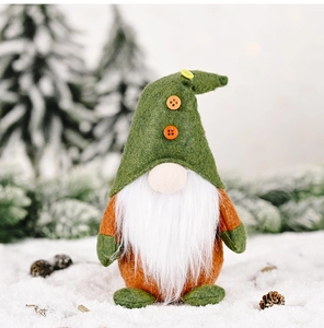 Close-up of green felt Christmas gnome with white beard and button details on snow