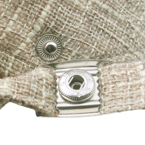 Makrodetail der Leinen-Schirmmütze mit verzierten Metalldruckknöpfen und Webmuster