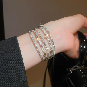 Detailed macro view of multilayer pearl bracelet with rhinestone heart and star charms