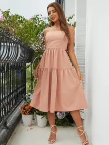 Detail of peach backless maxi dress with thin straps and ruffled tiered hemline