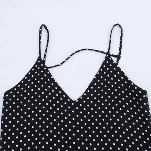 Abito nero a pois con scollo a V e spalline sottili su sfondo bianco professionale