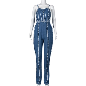 Détail d'une combinaison en denim bleu avec coutures effilochées blanches et coupe ajustée