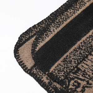 Macro view of double-sided knit scarf showing intricate deer pattern and hem stitching