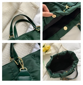 Detail view of dark green quilted tote showing magnetic closure and golden metal hardware