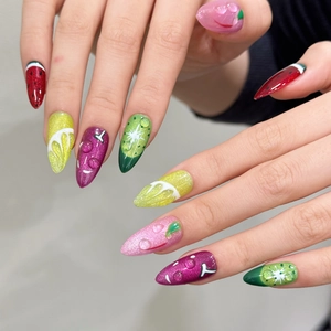 Macro view of long stiletto press-on nails with fruit art and 3D water drops
