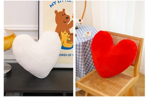 Detail showing plush heart-shaped pillows in white and red colors for home decor