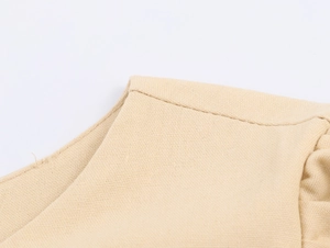 Macro shot of beige cotton linen embroidery and stitched seam on women's dress