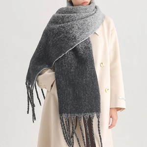 Detail of gray-black gradient scarf with fringes on a beige coat for winter