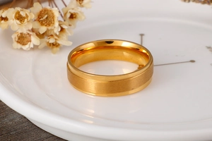 Dettaglio dell'anello in acciaio al titanio dorato con superficie spazzolata e bordi lucidi