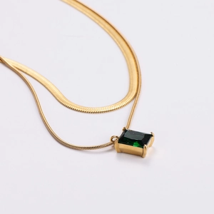 Elegant double layered gold necklace featuring a rectangular green zircon pendant on white base