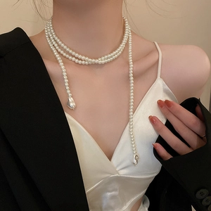 Détail du long collier de perles élégant avec design multicouche et pendentif rétro