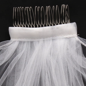 Detailed close-up of a white bridal veil mesh securely attached to a silver metal hair comb