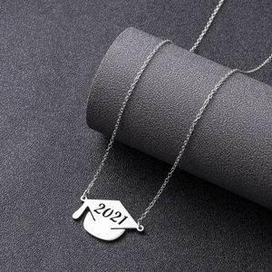 Silver stainless steel graduation cap necklace with 2021 pendant on textured display