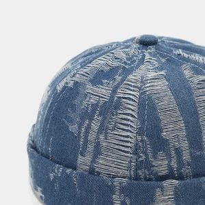 Close-up of distressed denim miki hat with frayed texture and vintage wash detail