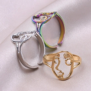 Abstract line face rings in gold, silver, and rainbow finishes on silk fabric