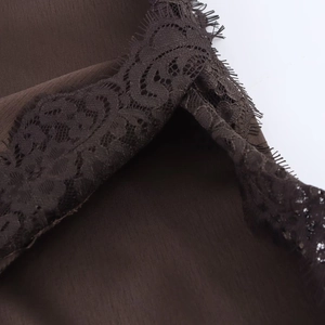 Detail of dark brown satin fabric with intricate lace trim and silky texture