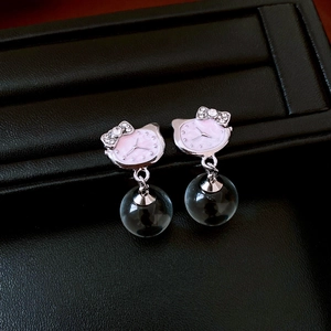 Detailed close-up of Hello Kitty earrings with pink enamel, rhinestones and glass beads