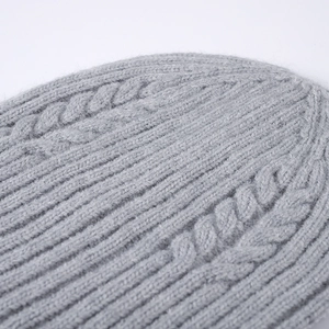 Women's grey cable knit beanie hat featuring warm ribbed texture and cozy wool blend fabric