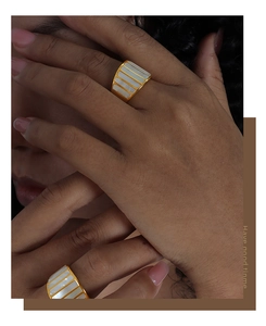 Detail of 18K gold plated steel ring with white shell inlay and geometric stripes