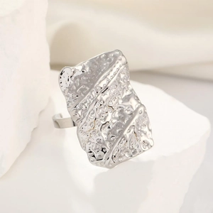 Detailed macro view of silver stainless steel ring featuring unique irregular pleated texture