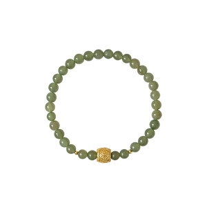 Detailed close-up of green crystal beads and a golden charm with traditional engraving
