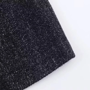 Macro shot of black tweed fabric with shimmering silver metallic threads on white background