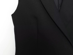 Dettaglio del colletto a rever e spalline di un abito blazer nero in tessuto twill