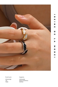 Detailed view of irregular 18K gold-plated rings with black and white drip oil insets