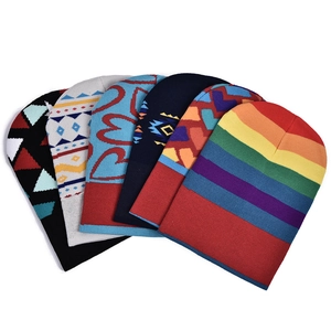 Detailed flat lay of colorful rainbow striped beanies and geometric pattern winter hats