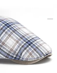 Close-up of blue and brown plaid flat cap showing the wide curved brim detail