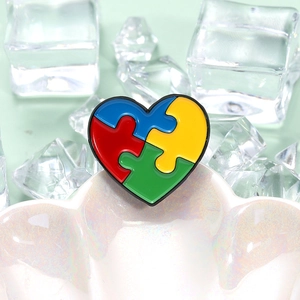 Colorful enamel heart puzzle piece badge on white shell with bright crystal decor