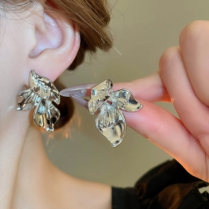 Silver wrinkled metal leaf stud earrings on model for a minimalist geometric look