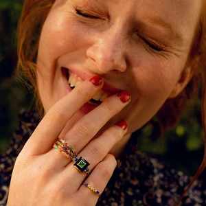 Close-up of S925 silver 18K gold rings with colorful gemstones and blue enamel