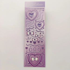 Detail of purple Y2K aesthetic stickers with 3D hearts, bows and pearl chain designs