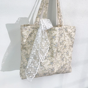 Close-up of floral canvas tote bag with blue flowers and delicate white lace trim detail