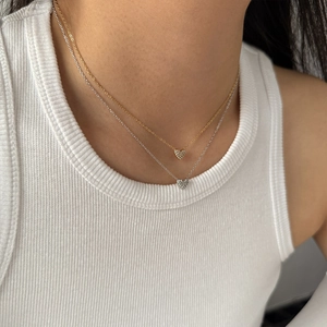 Minimalist heart pendant necklaces in gold and silver with pave zircon on model