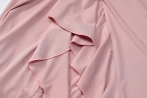 Detailed macro shot of pink layered ruffles and high-density stitching on the dress
