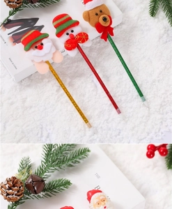 Close-up of festive Christmas pens with Santa and reindeer plush tops on snow background