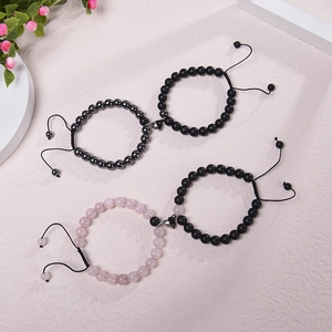 Detail of magnetic heart charms on beaded couple bracelets with adjustable black cord