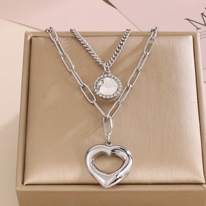 Dettaglio macro della collana doppia argentata con pendenti a cuore e cristallo