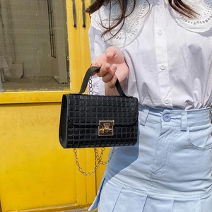 Black quilted small crossbody bag with gold chain strap and metal lock closure
