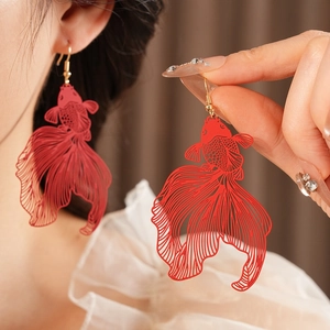 Élégantes boucles d'oreilles carpe koï rouge en métal évidé portées par un mannequin