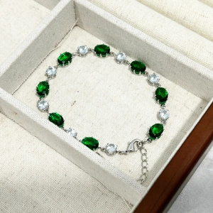 Détail du bracelet en pierres vert émeraude ovales avec fermoir homard et chaîne réglable