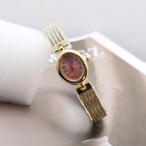 Detailed macro shot of an oval gold watch featuring a purple sunray dial with crystal strap