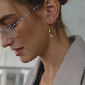 Elegant 18K gold plated stainless steel drop earrings with white zircon tassels on a model