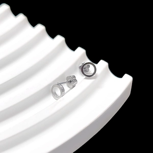 Detailed close-up of silver geometric hoop earrings with unique petal shaped backings