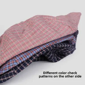 Detail of reversible plaid bucket hat showing multiple color patterns and cotton texture